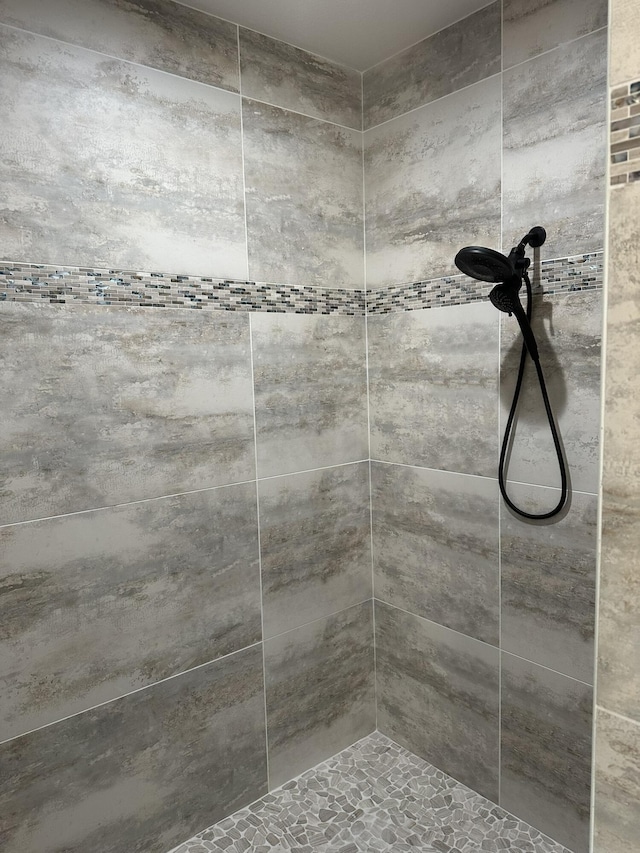 interior details featuring a tile shower