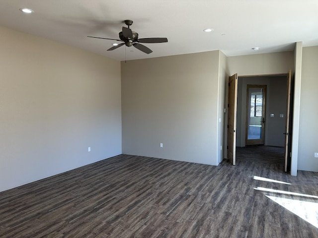 empty room featuring dark wood-type flooring and ceiling fan