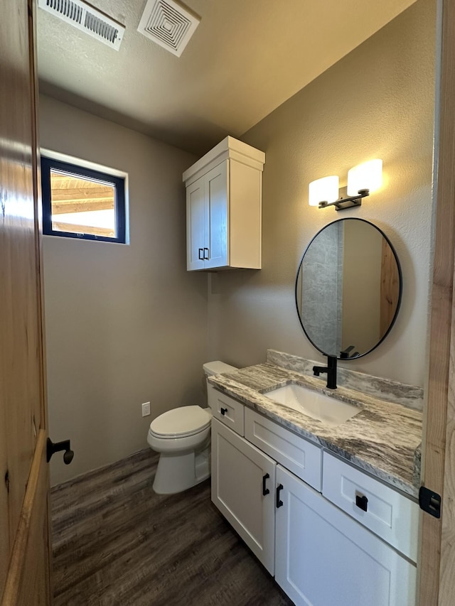 bathroom with vanity, wood-type flooring, and toilet