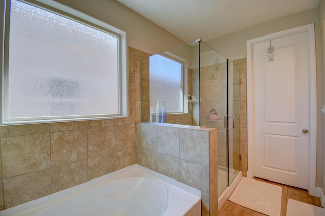 bathroom with hardwood / wood-style floors and shower with separate bathtub