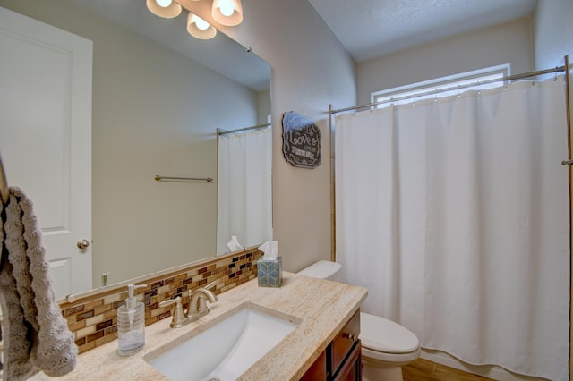 bathroom featuring a shower with curtain, backsplash, vanity, and toilet