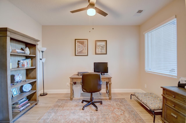 office area with ceiling fan, light wood finished floors, visible vents, and baseboards