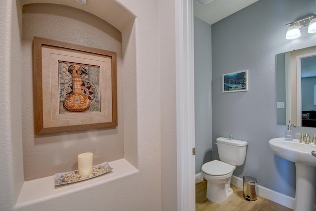 bathroom with hardwood / wood-style flooring, sink, and toilet