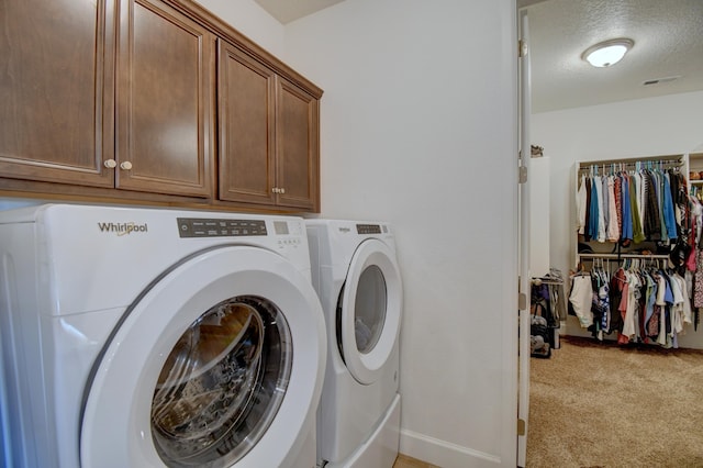 laundry room featuring light carpet, cabinets, a textured ceiling, and independent washer and dryer