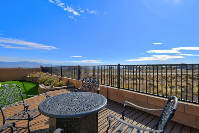 deck with a fenced backyard and a mountain view