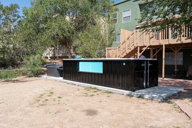 view of gate featuring a wooden deck and a patio