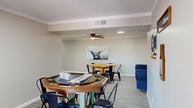 dining space with light hardwood / wood-style floors, ceiling fan, and crown molding