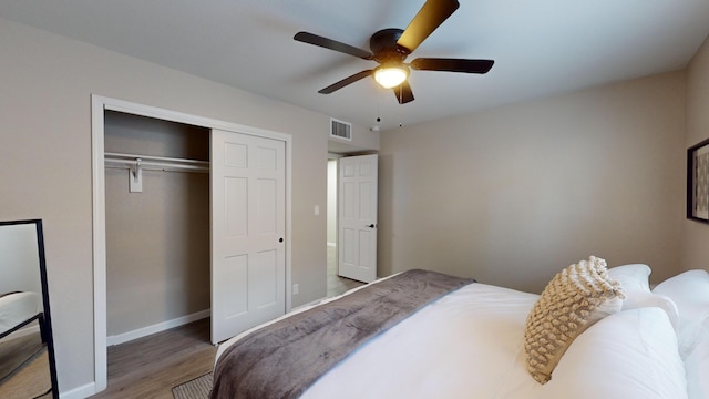 bedroom featuring hardwood / wood-style flooring, ceiling fan, and a closet