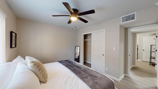 bedroom with ceiling fan, light hardwood / wood-style floors, and a closet