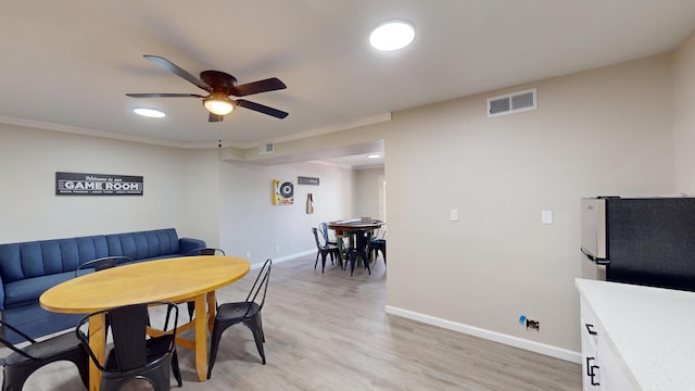 dining room featuring ceiling fan, crown molding, and light hardwood / wood-style floors