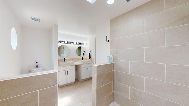 bathroom with tile patterned flooring, a shower, vanity, and toilet