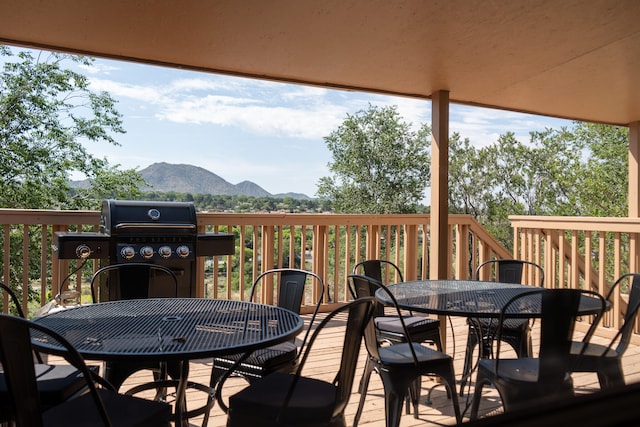 wooden terrace featuring a mountain view and a grill