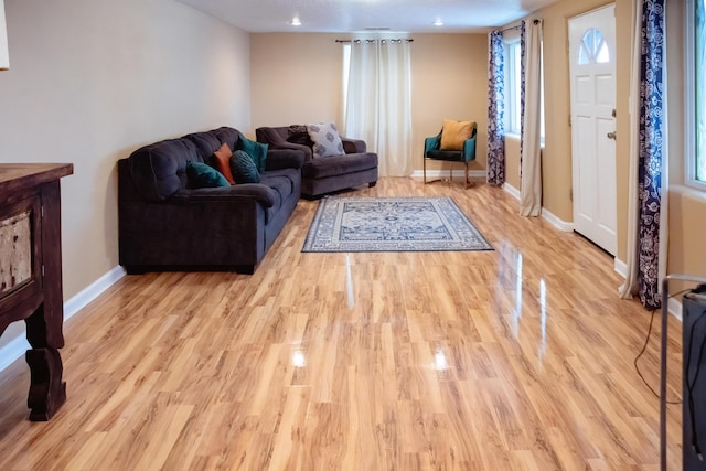 living room with plenty of natural light, light wood-style flooring, and baseboards