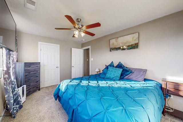 bedroom with light carpet, ceiling fan, and visible vents