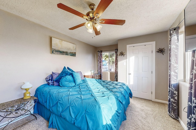 bedroom featuring a ceiling fan, light carpet, a textured ceiling, and baseboards