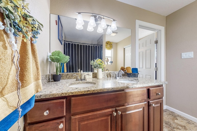 full bathroom with a shower with shower curtain, a sink, baseboards, and double vanity