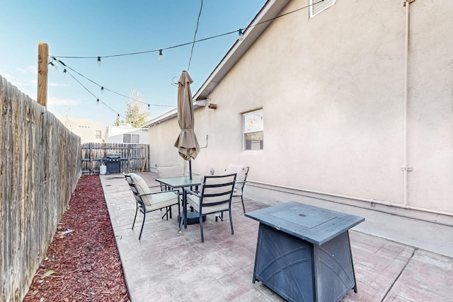 view of patio / terrace with outdoor dining area, a fenced backyard, and a grill