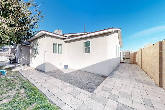 back of property featuring a patio area, fence, and stucco siding