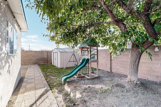 view of jungle gym with a fenced backyard, an outbuilding, and a shed