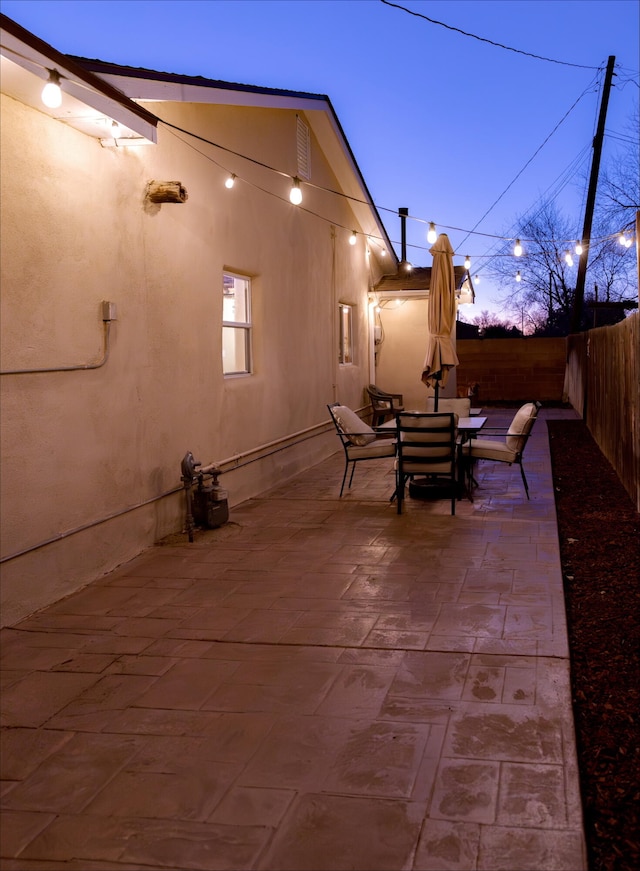 patio terrace at dusk with a fenced backyard