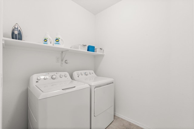 laundry room featuring light tile patterned floors and washing machine and clothes dryer