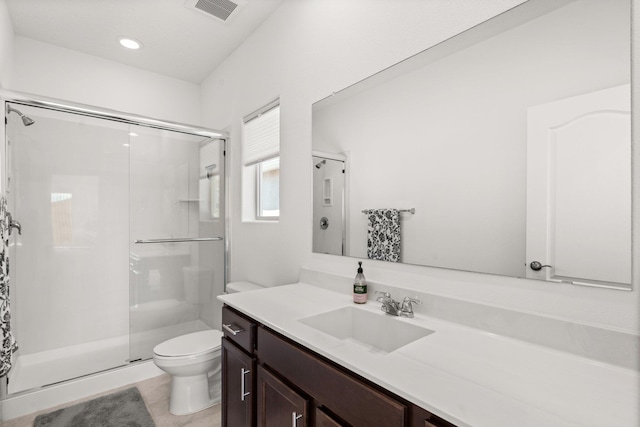 bathroom featuring tile patterned flooring, vanity, an enclosed shower, and toilet