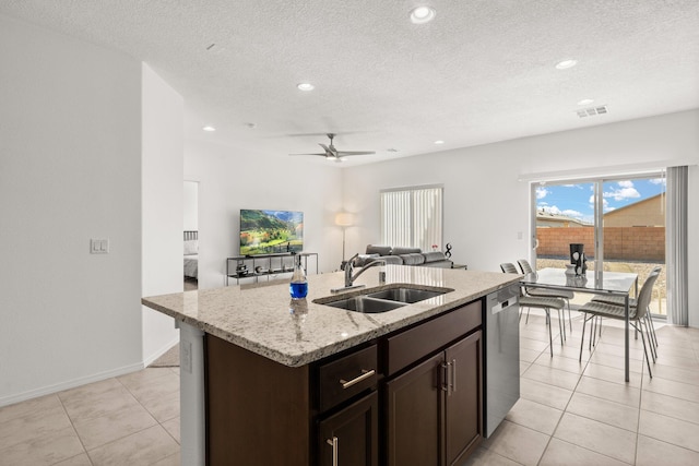 kitchen with dishwasher, a kitchen island with sink, sink, ceiling fan, and a textured ceiling