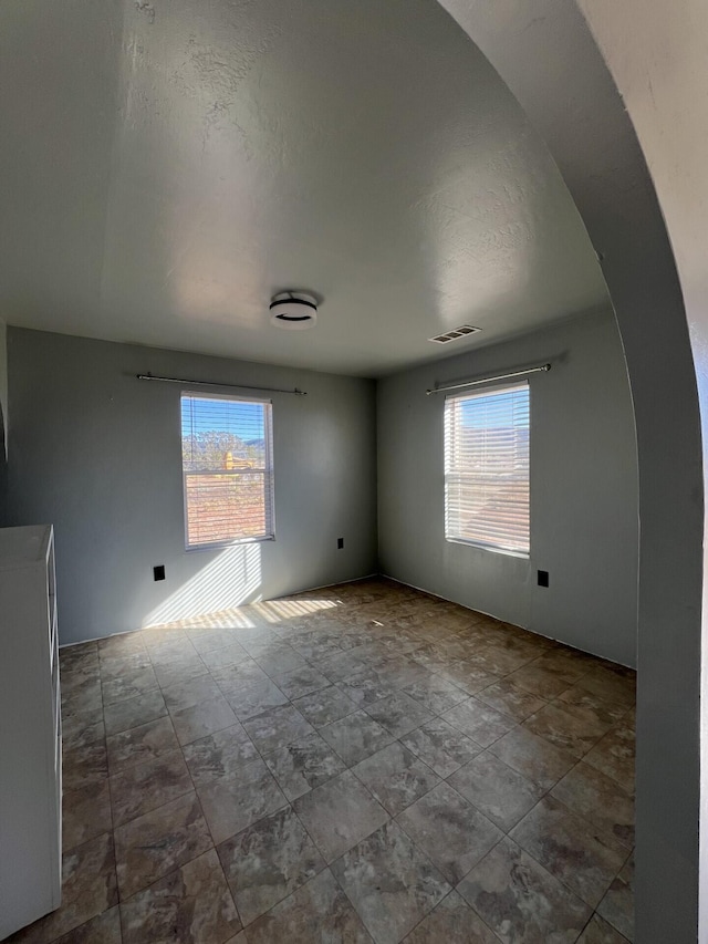 empty room featuring plenty of natural light and a textured ceiling