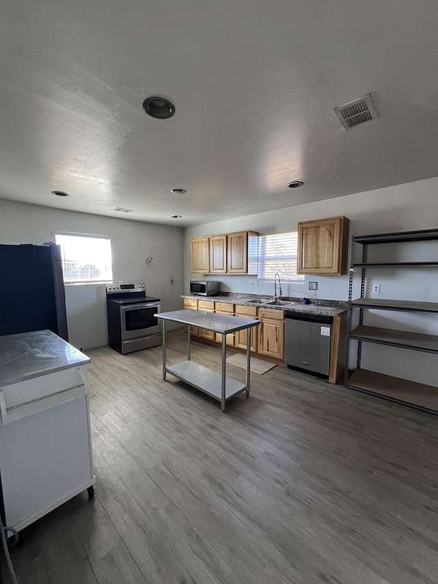 kitchen with sink, wood-type flooring, and appliances with stainless steel finishes