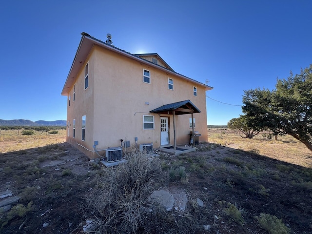 back of house with a mountain view and cooling unit