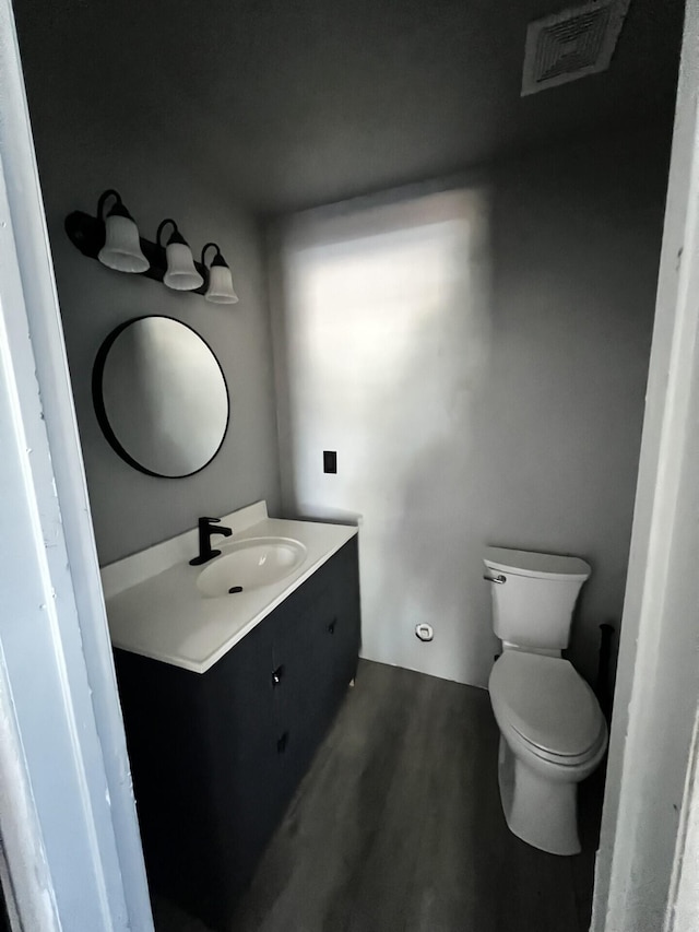 bathroom featuring vanity, hardwood / wood-style flooring, and toilet