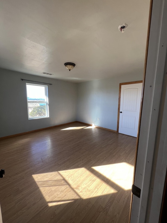 unfurnished room with hardwood / wood-style flooring