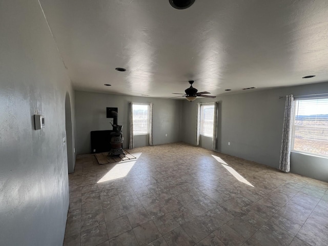 empty room with ceiling fan and a wealth of natural light