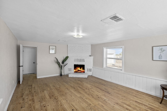 unfurnished living room featuring a fireplace and light hardwood / wood-style floors