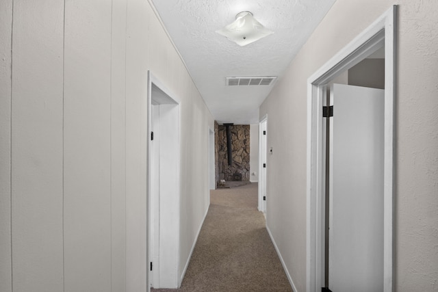 hall with a textured ceiling and carpet floors