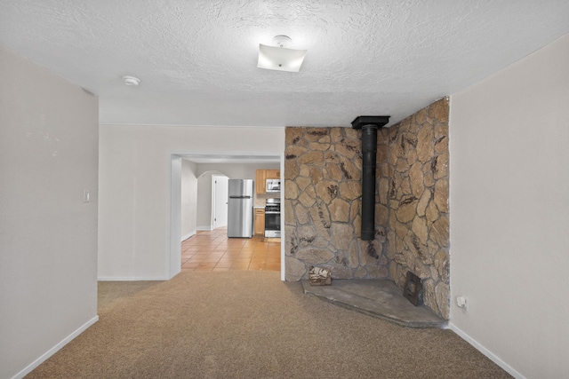 unfurnished living room with light carpet and a textured ceiling