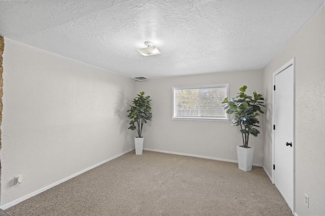 carpeted spare room with a textured ceiling