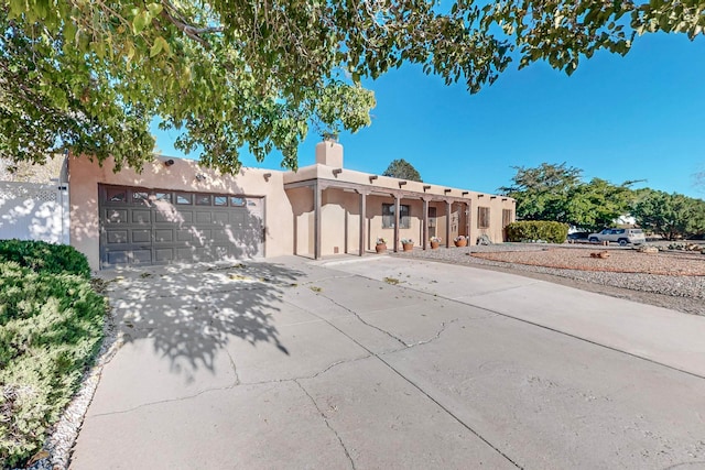 pueblo revival-style home featuring a garage