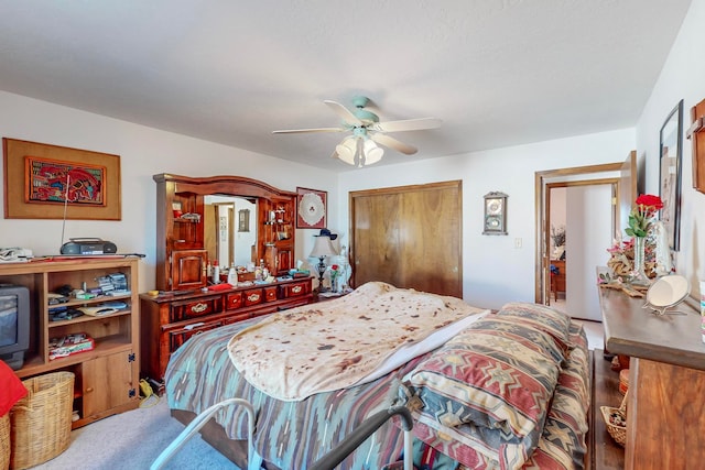 carpeted bedroom featuring ceiling fan and a closet