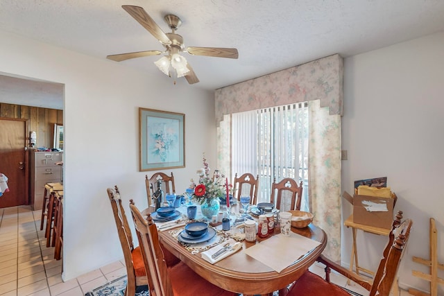 tiled dining room with ceiling fan and a textured ceiling