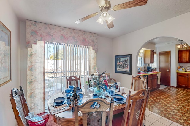 tiled dining area featuring ceiling fan and plenty of natural light