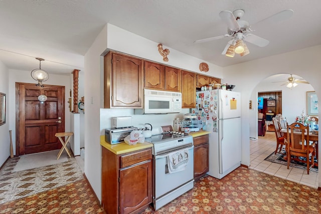 kitchen with pendant lighting, ceiling fan, white appliances, and light tile patterned floors