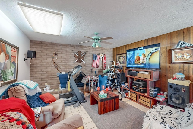 office space with ceiling fan, wood walls, light tile patterned floors, and a textured ceiling