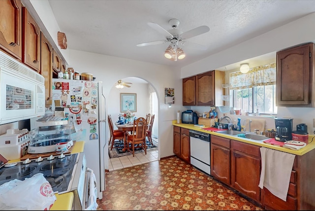 kitchen featuring a textured ceiling, ceiling fan, sink, and white appliances