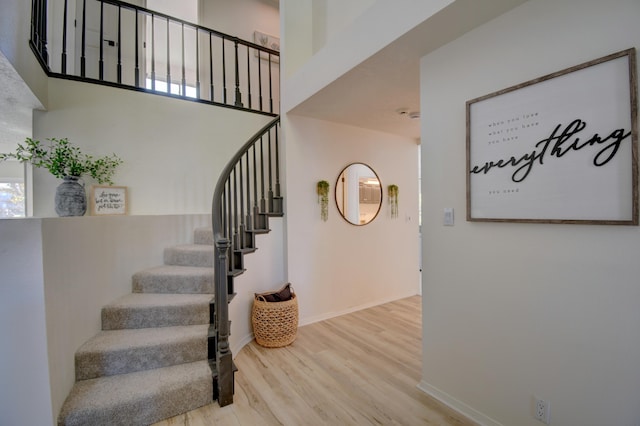 stairs with a high ceiling and hardwood / wood-style flooring