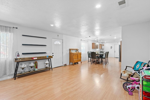 interior space featuring a textured ceiling and light wood-type flooring