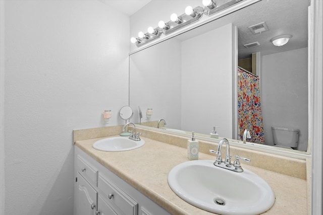 bathroom featuring vanity, toilet, and a textured ceiling