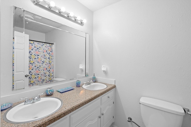 bathroom with a shower with shower curtain, vanity, and toilet