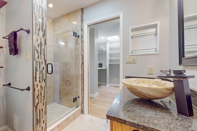 bathroom featuring hardwood / wood-style floors, vanity, and an enclosed shower