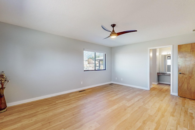 interior space with ensuite bath, light hardwood / wood-style flooring, and ceiling fan